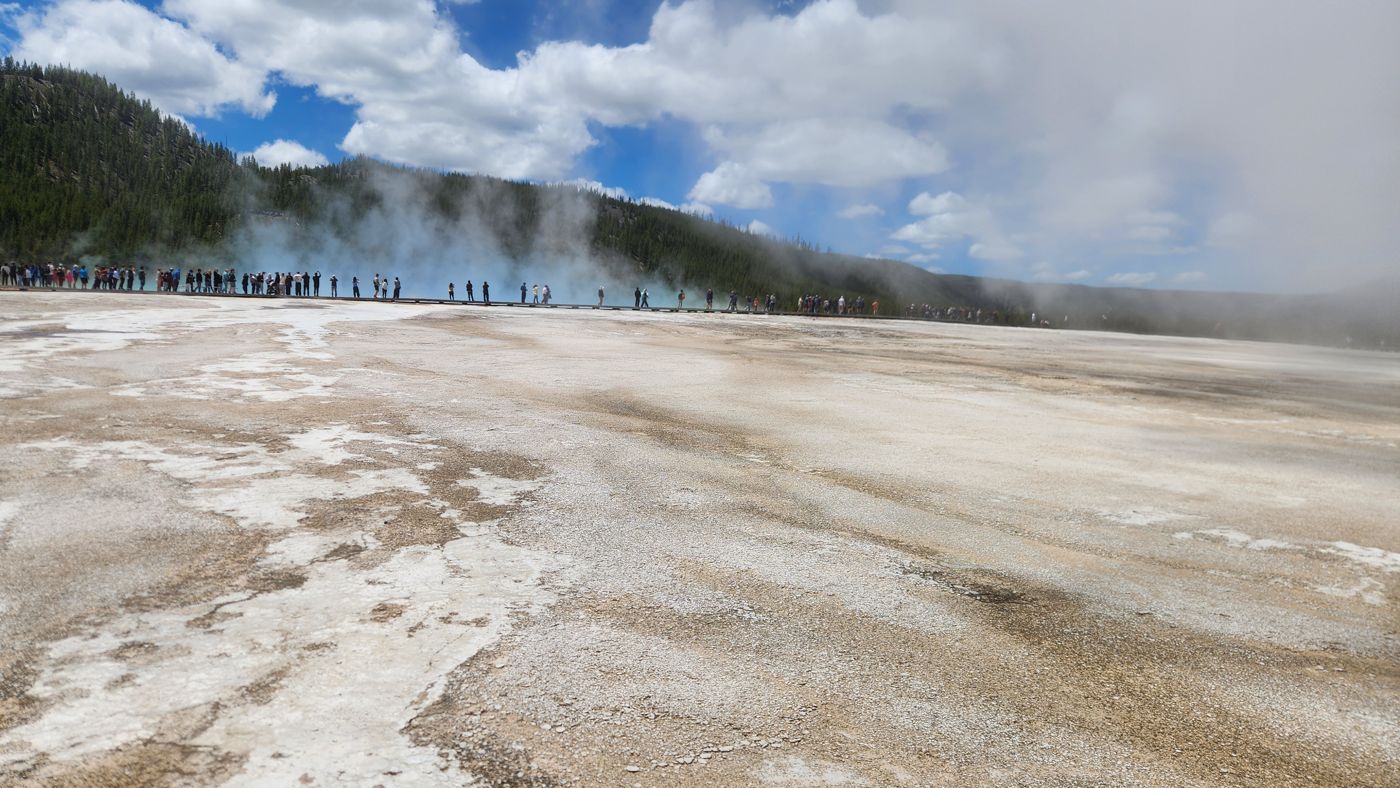 The orange and turquoise bands of Grand Prismatic Spring under a blue sky