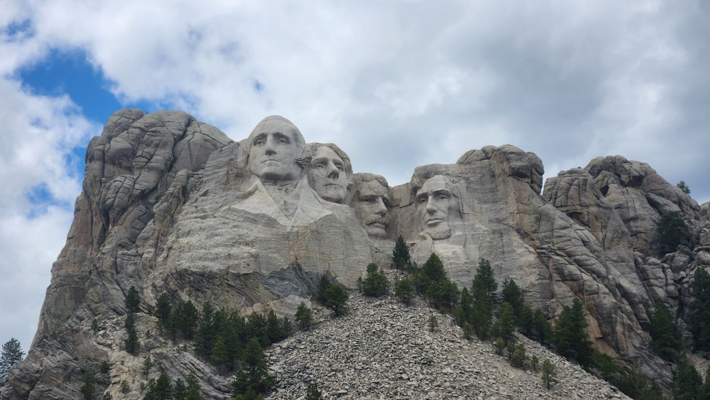 The four presidents' faces of Mount Rushmore against a cloudy sky